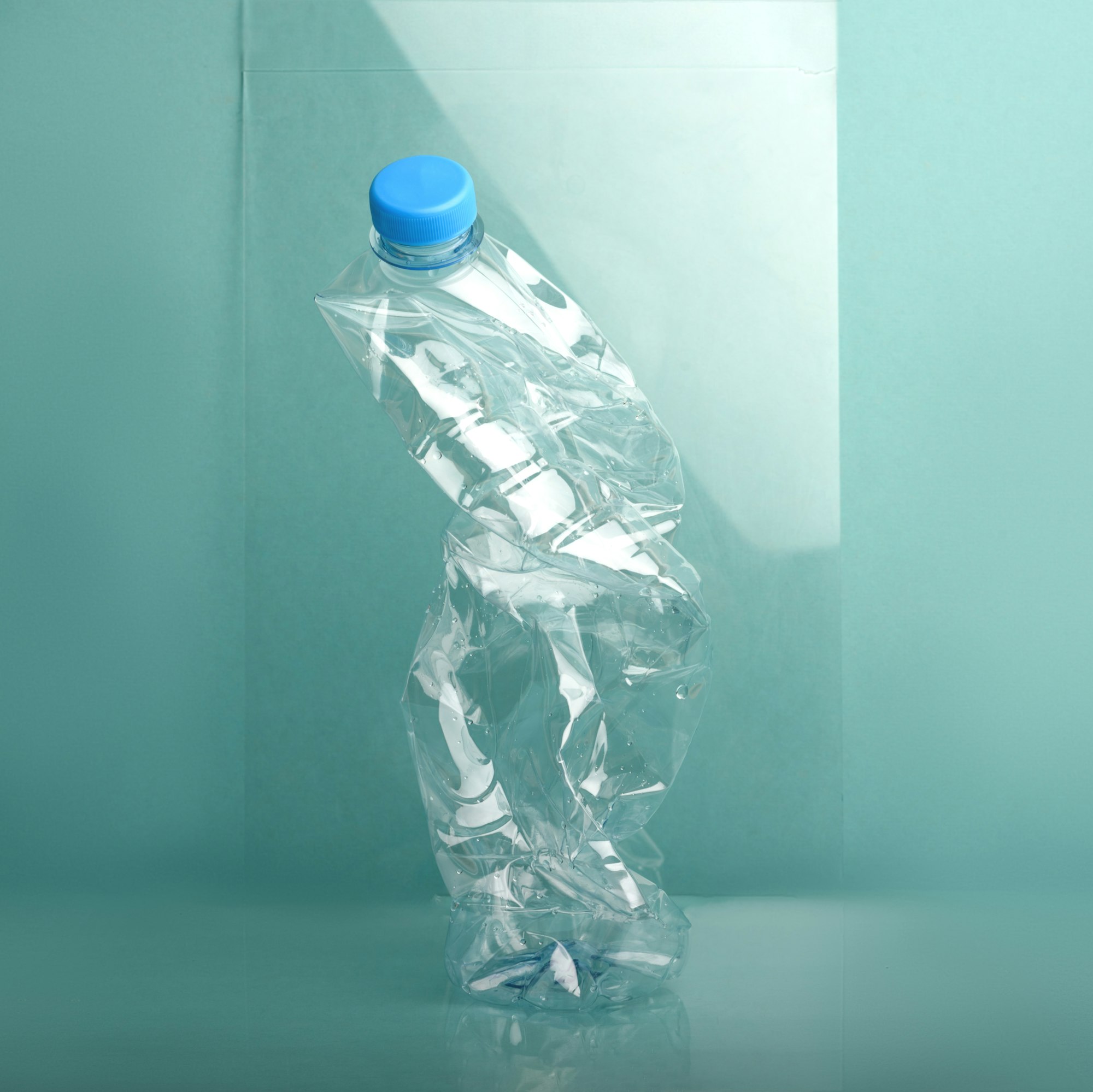 Used crushed plastic bottle on blue background.
